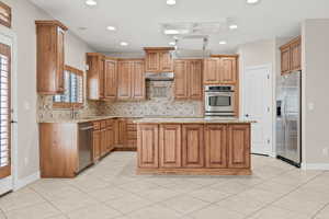 Kitchen featuring stainless steel appliances with granite countertops and huge center island