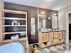 Full bath featuring a shower with shower door, visible vents, a sink, double vanity, and baseboards