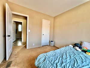 Bedroom with visible vents and carpet floors
