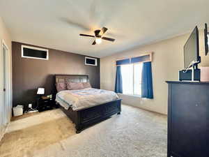 Carpeted bedroom featuring a ceiling fan