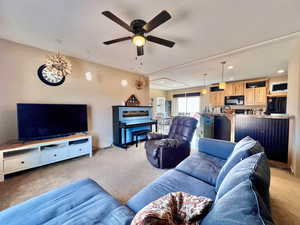 Living area with light carpet, recessed lighting, and a ceiling fan
