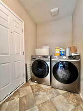 Washroom featuring washing machine and dryer and laundry area