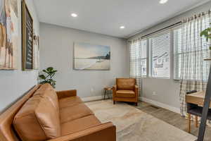 Sitting room with wood finished floors, baseboards, and recessed lighting