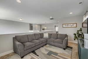Living room featuring baseboards, visible vents, and recessed lighting