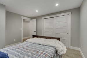 Carpeted bedroom featuring a closet, recessed lighting, and baseboards
