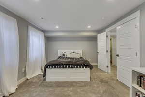 Carpeted bedroom with visible vents, baseboards, and recessed lighting