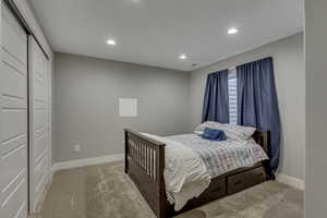 Carpeted bedroom with recessed lighting and baseboards