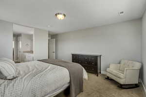 Bedroom with light carpet, visible vents, and baseboards