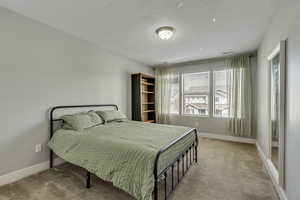Carpeted bedroom with baseboards and a textured ceiling