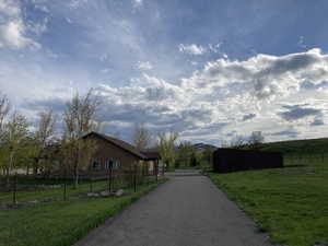 View of asphalt driveway with a view of rural / pastoral area