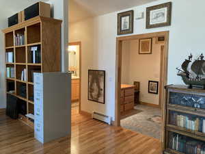 Office with light wood finished floors and a baseboard radiator