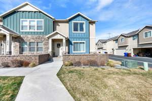 Craftsman inspired home with board and batten siding, a front yard, and a residential view