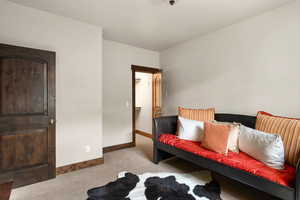 Living area with baseboards and carpet