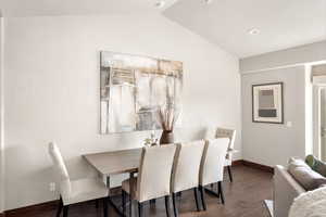Dining room featuring baseboards, vaulted ceiling, wood finished floors, and recessed lighting
