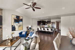Living area featuring dark wood finished floors, lofted ceiling, ceiling fan, and recessed lighting