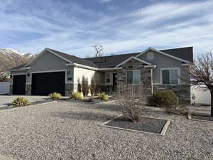 View of front facade with concrete driveway, stucco siding, a mountain view, stone siding, and a garage