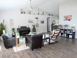 Living area featuring high vaulted ceiling, arched walkways, visible vents, and LVP floors