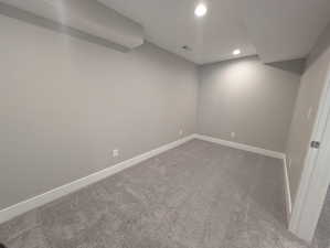 Finished below grade area with recessed lighting, dark colored carpet, visible vents, and baseboards