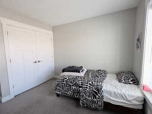 Carpeted bedroom featuring a closet and baseboards