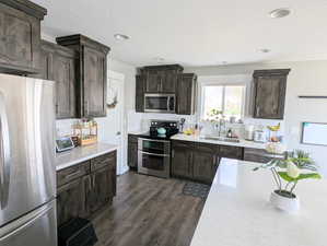 Kitchen featuring decorative backsplash, a sink, and appliances with stainless steel finishes