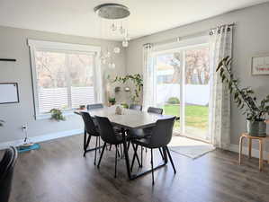 Dining space featuring dark wood-style flooring and baseboards