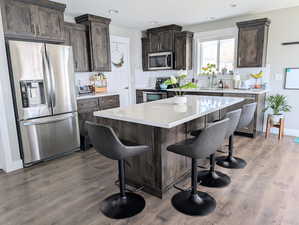 Kitchen featuring stainless steel appliances, a sink, a kitchen breakfast bar, and backsplash