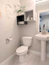 1/2 Bathroom featuring toilet, a sink, and baseboards