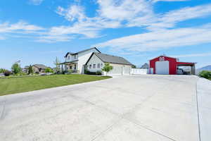 Modern Farmhouse with barndoor Breezeway enclosure between the residence and 3 car carriage garage and view of additional barn with lean-to.