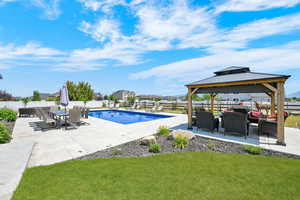 View of pool with a fenced backyard, a patio, and a gazebo