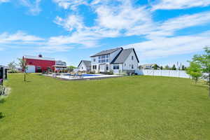 Rear view of property with a patio area, a pool, and a fenced backyard