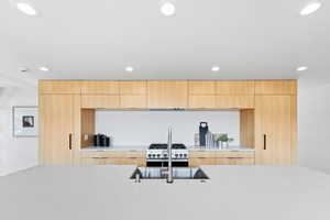 Kitchen featuring light brown cabinets, modern cabinets, and recessed lighting
