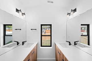 Bathroom featuring vanity, visible vents, and baseboards