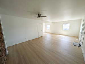 Unfurnished room featuring light wood finished floors, baseboards, and a ceiling fan