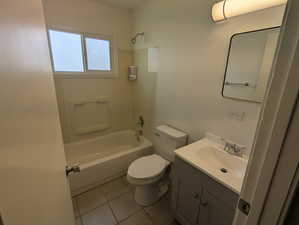 Bathroom with tile patterned floors, vanity, bathtub / shower combination, and toilet