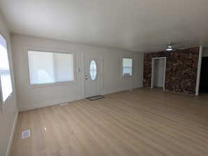 Entryway with visible vents, baseboards, light wood-type flooring, and a ceiling fan