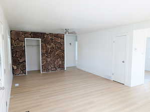 Spare room with light wood-style floors, baseboards, a ceiling fan, and visible vents