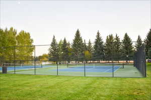 View of sport court featuring a yard and fence