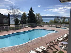 Community pool featuring a patio, fence, and a mountain view