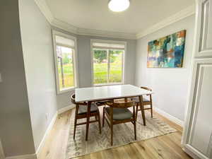 Dining room featuring crown molding, baseboards, and light wood-type flooring