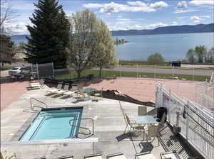 Pool featuring a patio, fence, and a water and mountain view