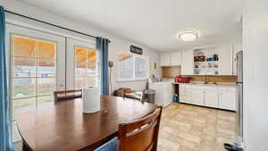Dining area with french doors, washer and dryer, and light floors
