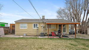 Rear view of house with a patio, roof with shingles, central air condition unit, fence, and a lawn