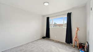 Empty room featuring baseboards, visible vents, and carpet floors