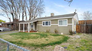 View of front facade featuring fence and a front lawn