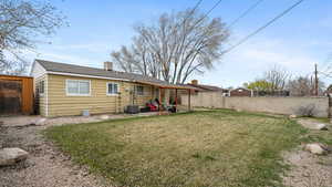 Back of house featuring central AC unit, a lawn, a patio, and fence private yard