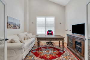 Office with wood finished floors and lofted ceiling