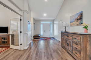 Foyer featuring high vaulted ceiling, light wood finished floors, and baseboards