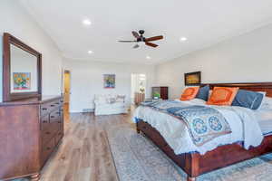 Bedroom with baseboards, ceiling fan, crown molding, light wood finished floors, and recessed lighting