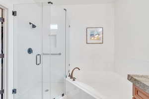 Full bath featuring a bath, a stall shower, and vanity