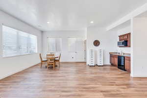 Unfurnished dining area featuring light wood-style flooring, recessed lighting, and baseboards